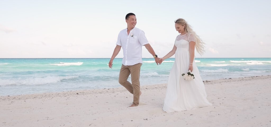 Bajo el cielo vasto y despejado de Cancún, los novios caminan descalzos por la orilla dorada. Cada paso en la suave arena es un paso hacia su futuro juntos, donde las olas besan sus pies como testigos del amor que los une. Sus manos entrelazadas son el lazo que une sus corazones, mientras comparten miradas llenas de promesas y sueños por cumplir. El murmullo del mar acompaña su caminar, como una sinfonía que celebra el inicio de una nueva aventura en este rincón paradisíaco del mundo.