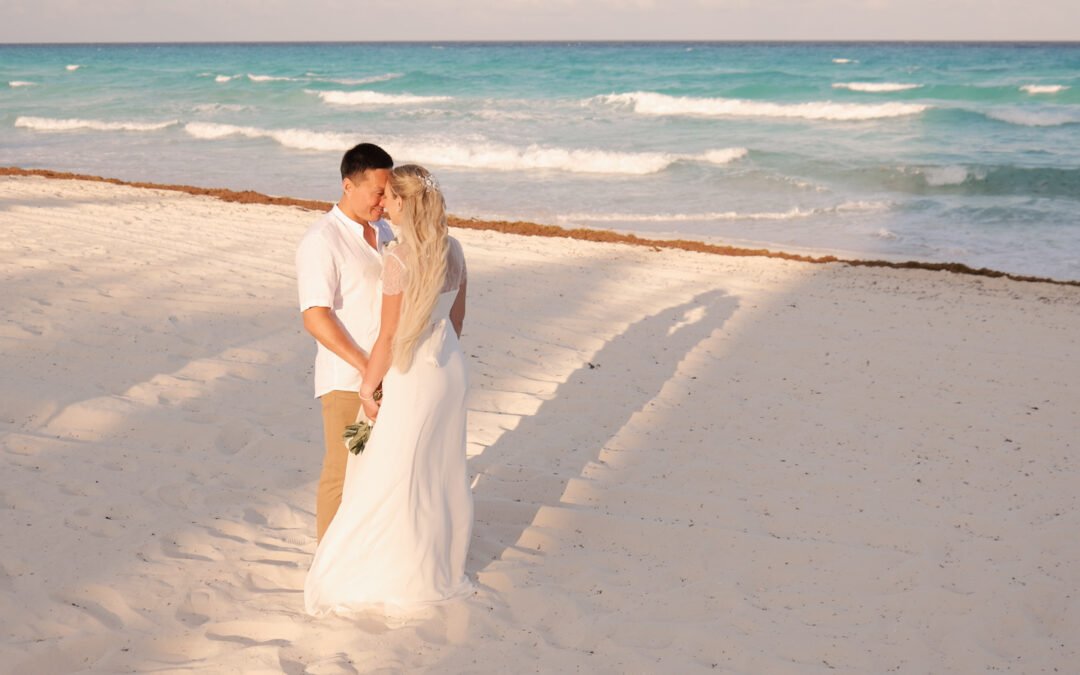 Bajo el resplandor del sol caribeño y el susurro de las olas turquesas, ellos caminan con pasos ligeros sobre la suave arena blanca. Vestidos de blanco, el mar de Cancún es testigo de su amor recién sellado, donde cada ola parece aplaudir su unión. Con cada paso, se adentran en un futuro lleno de promesas brillantes, mientras el cielo despejado y las palmeras les dan la bienvenida a su nueva vida juntos.