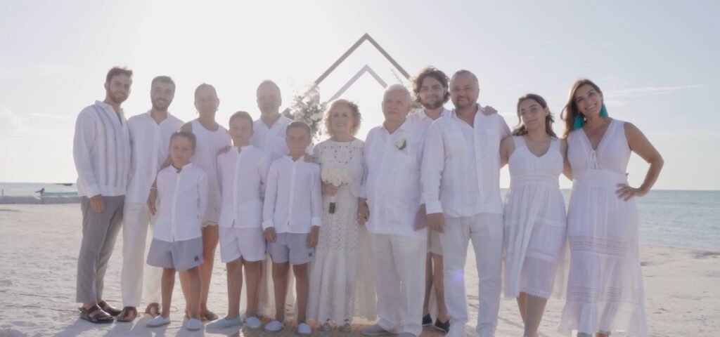 Sesión familiar en la playa, donde padres e hijos disfrutan juntos del sol y la brisa marina, capturando momentos de alegría y conexión en un entorno paradisíaco.